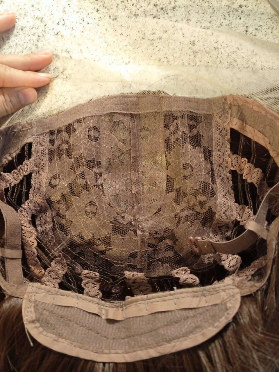 Close-up of a lace-trimmed hat on a textured surface
