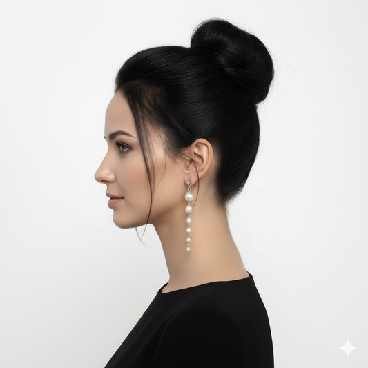 Woman with styled hair and pearl earrings on a white background