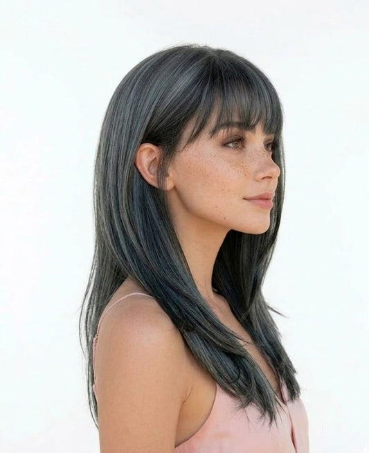 Woman with long dark hair and bangs on a white background