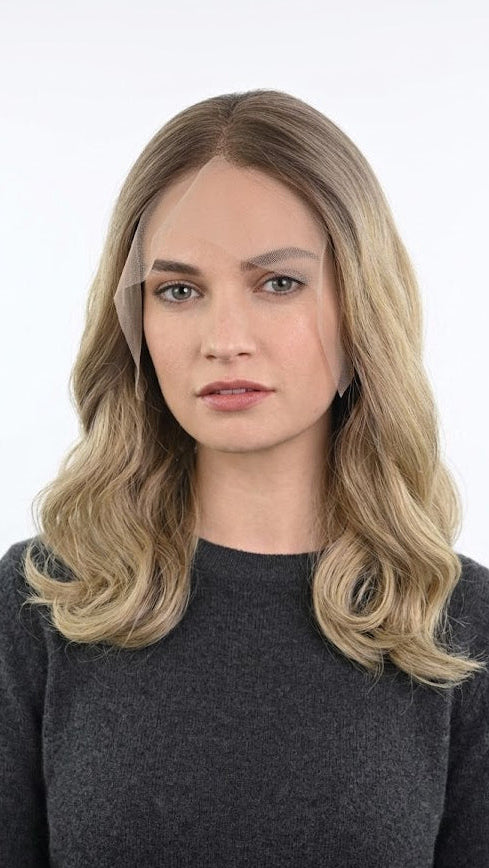 Woman with blonde hair wearing a face shield against a white background