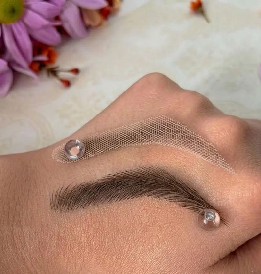 Eyebrow tattoo patch on a person's eyebrow with flowers in the background