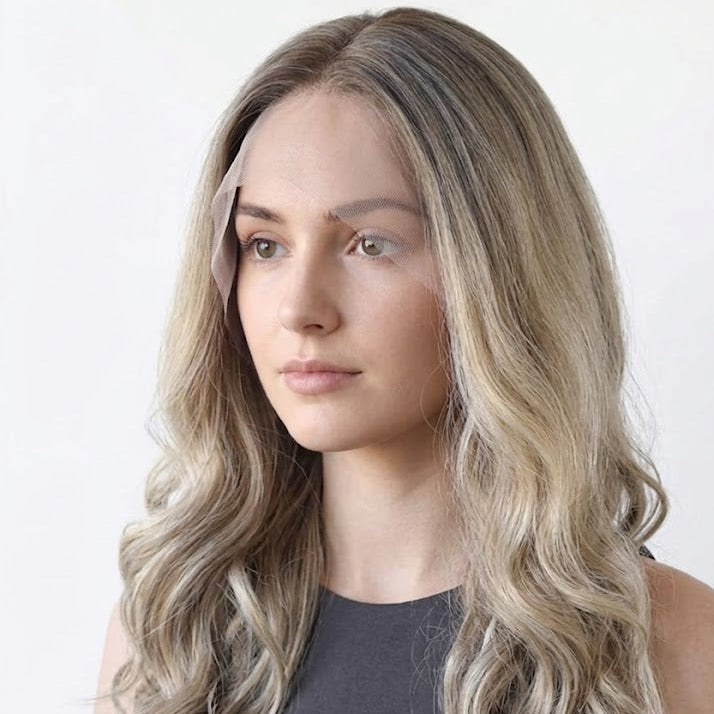Woman with long, wavy blonde hair against a white background