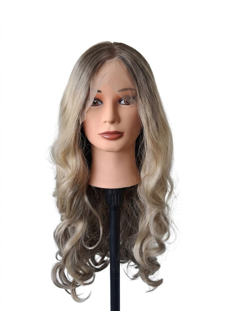 Mannequin head with wavy, gray-to-brown wig on a white background