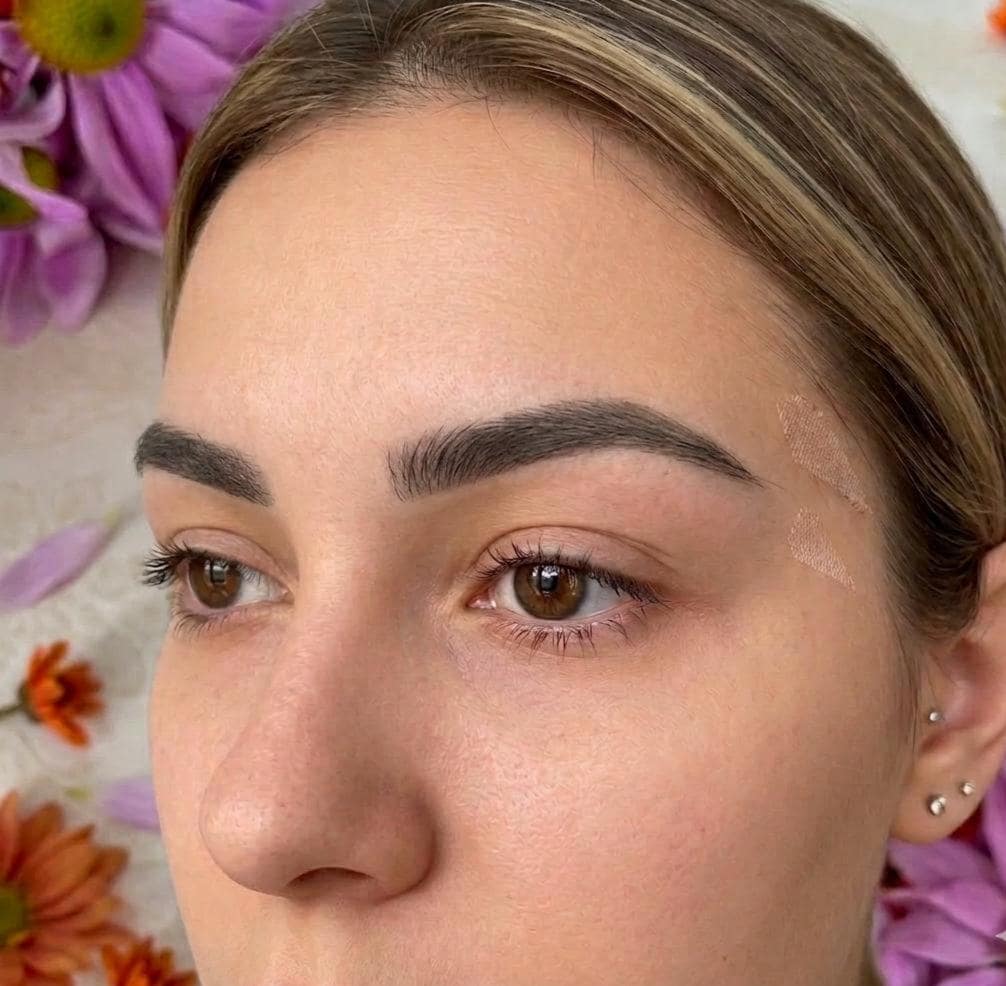 Close-up of a person's face with flowers in the background