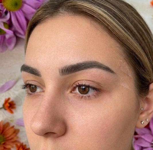 Close-up of a person's face with flowers in the background