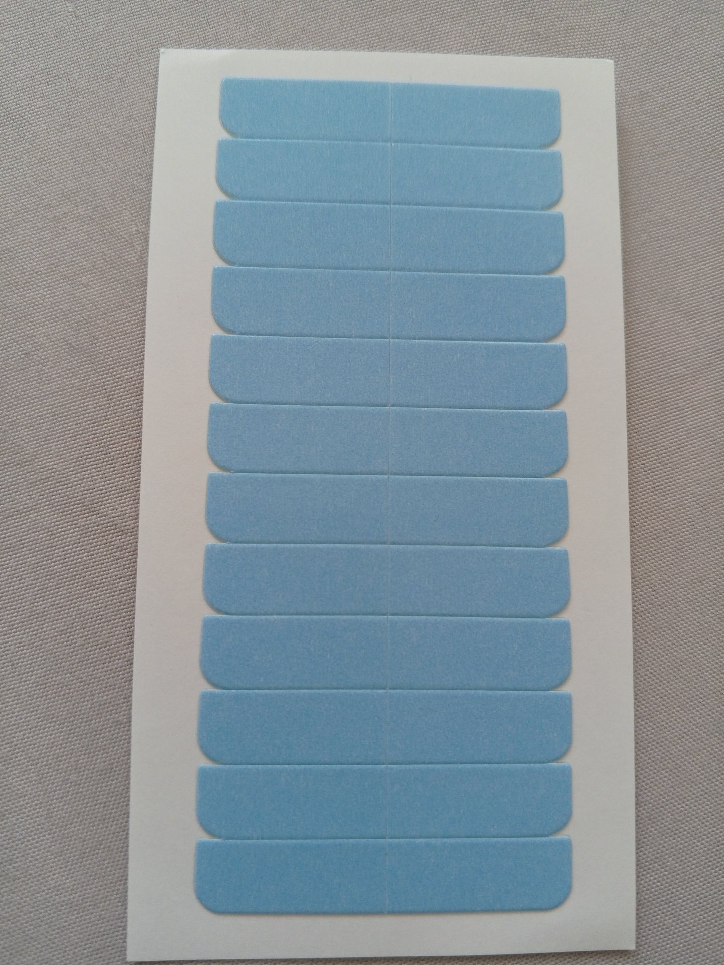 Sheet of blue adhesive labels on a gray background