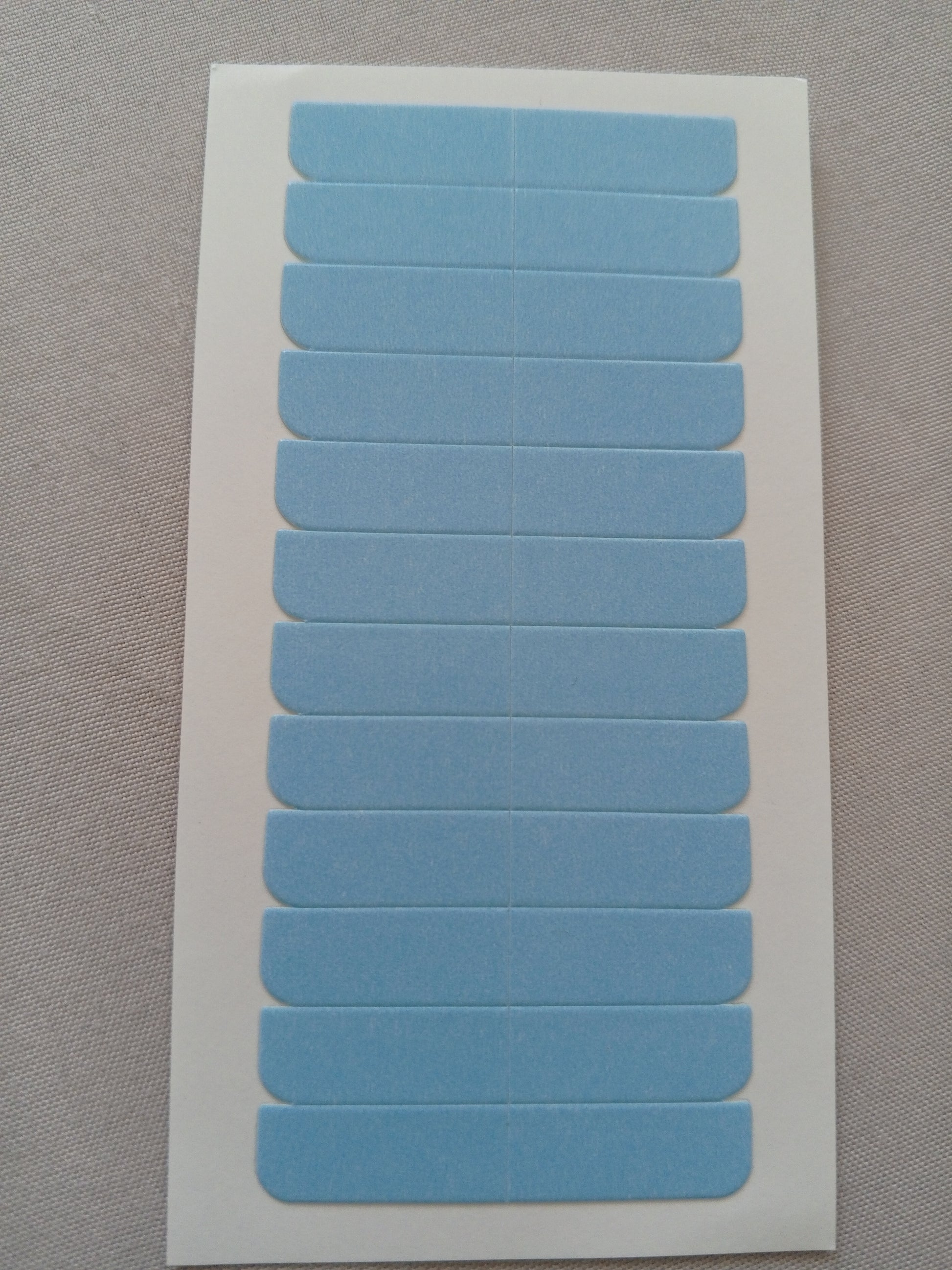 Sheet of blue adhesive labels on a gray background