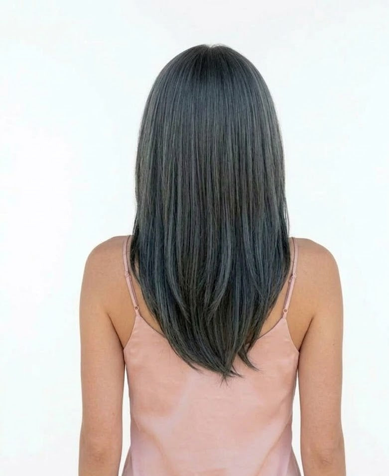 Person with long, straight hair wearing a pink top on a white background