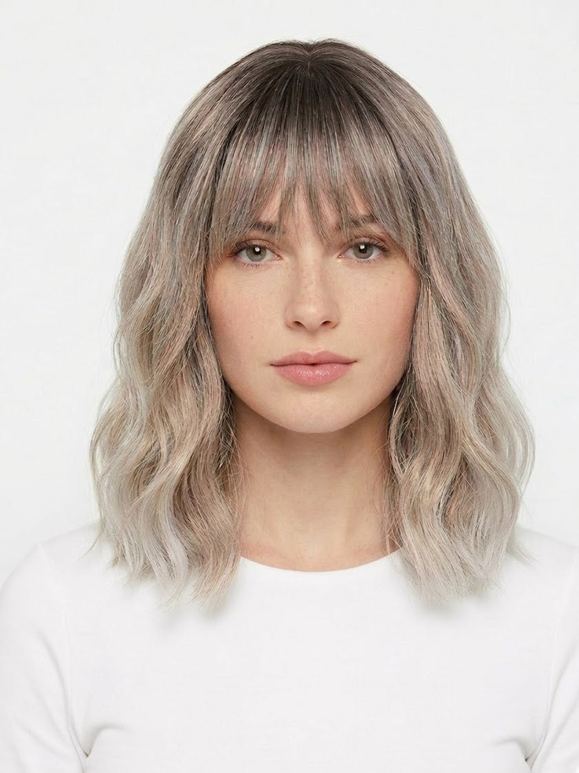 Woman with wavy, shoulder-length hair against a white background